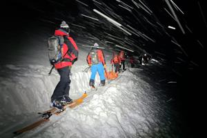 Bergretter bahnen sich den Weg mit Schaufeln durch den Schnee.
