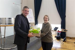Gruppenleiter Peter Skorsch überreicht Klima-Expertin Helga Kromp-Kolb einen "grünen" Nachhaltigkeitsgeschenkkorb.