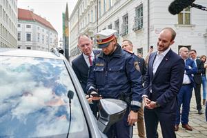 Innenminister Karner und Staatssekretär Tursky beobachten die Anwendung des digitalen Führerscheins bei einer simulierten Verkehrskontrolle.
