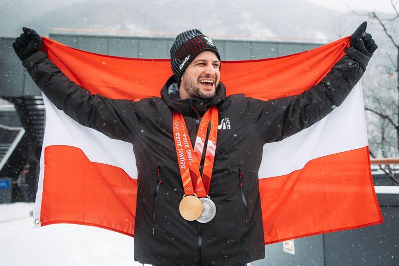 Der Polizei-Spitzensportler Johannes Strolz trägt die österreichische Fahne bei der Olympia-Abschlussfeier.
